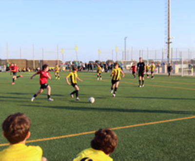 children playing soccer on a field with multiple players in yellow and black uniforms competing for the ball during a youth sports event focusing on teamwork and skills development